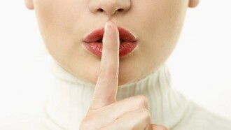 Un dedo ante los labios en señal de silencio