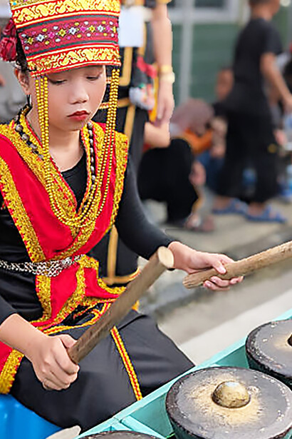 Young girl from Kazadan Dusun Penampang playing gong during the Kaamatan Harvest Festival, Malaysia