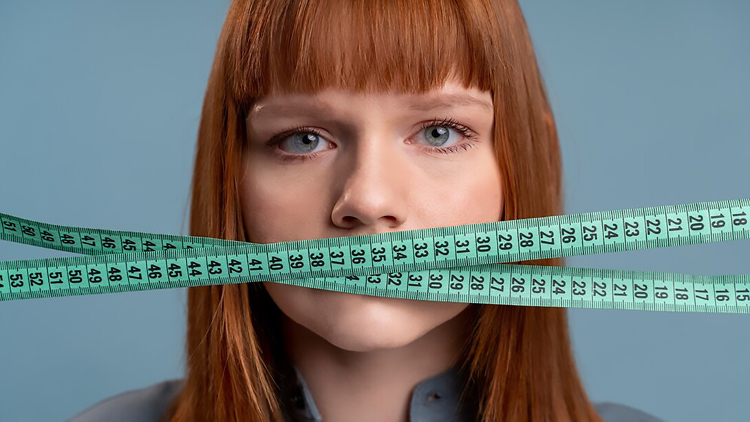 The personal struggle of a woman grappling with an eating disorder and weight issues, portrayed by holding a tape measure against her mouth, shedding light on the individual's journey and the complexities of body image and self-esteem