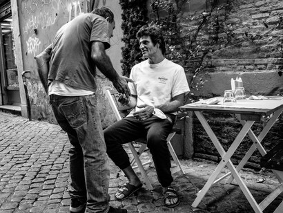 A traveller shares a light-hearted exchange with a local passing by, laughing as they debate the best spots in town to visit, further embracing the lively spirit of authentic travel