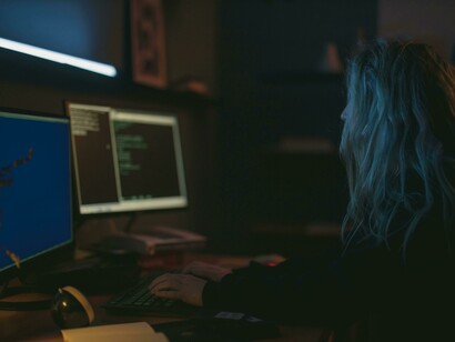A programmer typing on a keyboard, focused on her work
