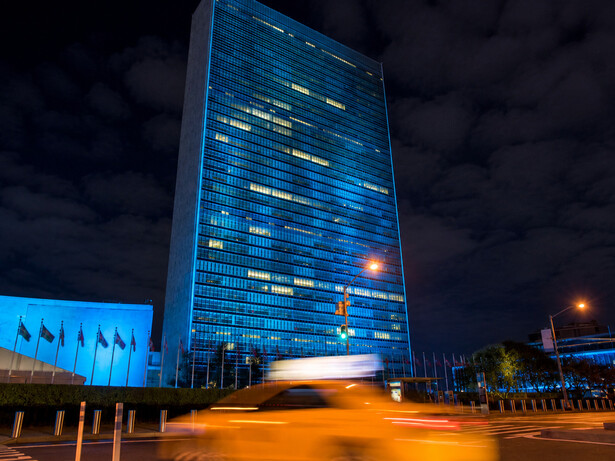 La sede de Naciones Unidas, Nueva York, Estados Unidos, aparece iluminada de azul como un símbolo de un orden internacional que aún intenta sostenerse entre guerras, tensiones y disputas de poder