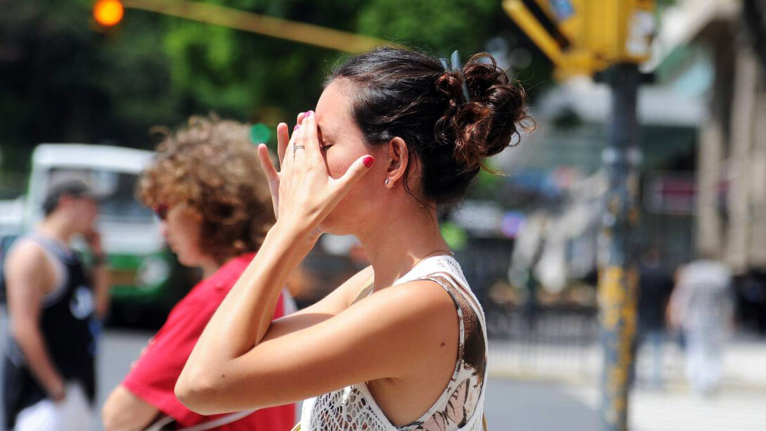 Mujer intenta cubrirse de las luz del sol por las altas temperaturas en esta nueva ola de calor