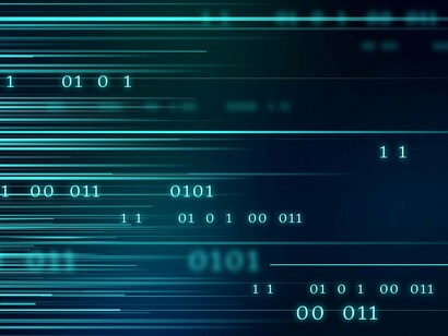 Binary codes lighting up on a screen, representing the relentless flow of information in connected enterprises
