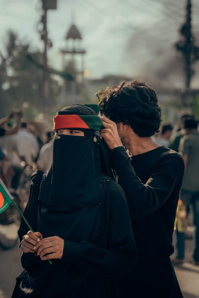 A couple of women stand side by side in Cumilla, Bangladesh, holding a sign that reads 'We Got Our Pride,' symbolizing the region's resilient struggle for unity and identity amidst ongoing political divisions