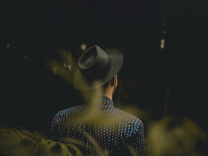 A man sitting on a bench, looking intently at the barren land