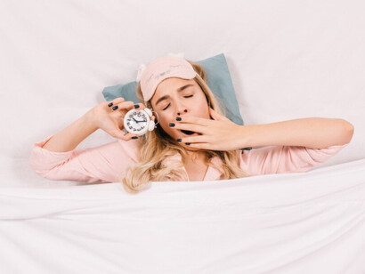 Tired woman yawning in bed, preparing to fall asleep peacefully