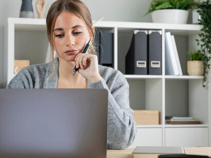 A woman working remotely at her desk, balancing work-from-home responsibilities with energy healing practices and maintaining a healthy work-life balance
