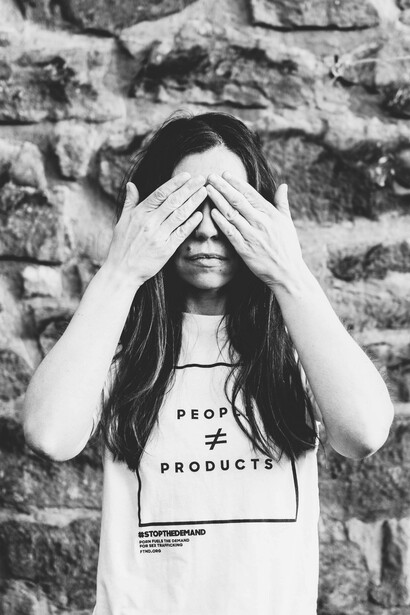 A woman covers her eyes so she cannot see what is happening