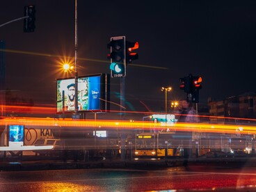 Night-time traffic streaking through a busy intersection, symbolizing a world moving faster than its systems of control
