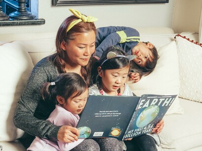 Mãe lendo com filhas