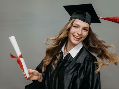 Woman holding a degree smiles