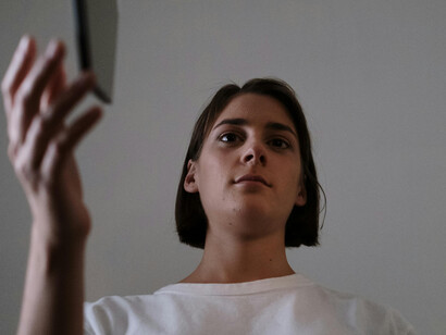 Lost in thought, she gazes into the distance, pondering the deeper questions of identity and authenticity in a world saturated with irony and self-awareness