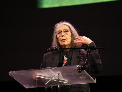 Su palabra nos recuerda que vivir no consiste en escapar del dolor, sino en aprender a descubrir, incluso en él, una forma de conocimiento. Anne Carson durante la lectura de los finalistas de los Premios Nacionales del Libro 2024. Centro Skirball de la Universidad de Nueva York, EE.UU.