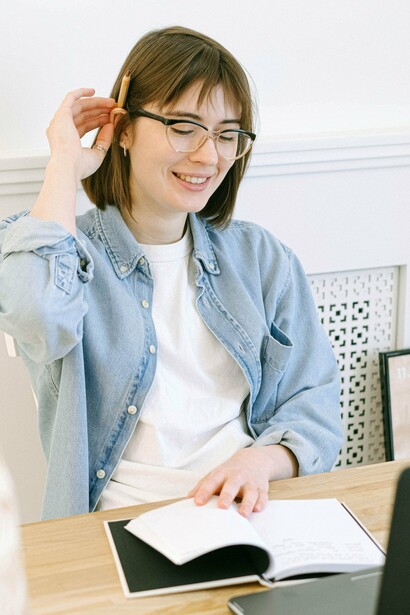 Uma mulher trabalha diante do computador, com um caderno e lápis sobre a mesa. A realização profissional pode trazer conquistas, mas nem sempre é suficiente para preencher a sensação de que algo ainda está fora do lugar