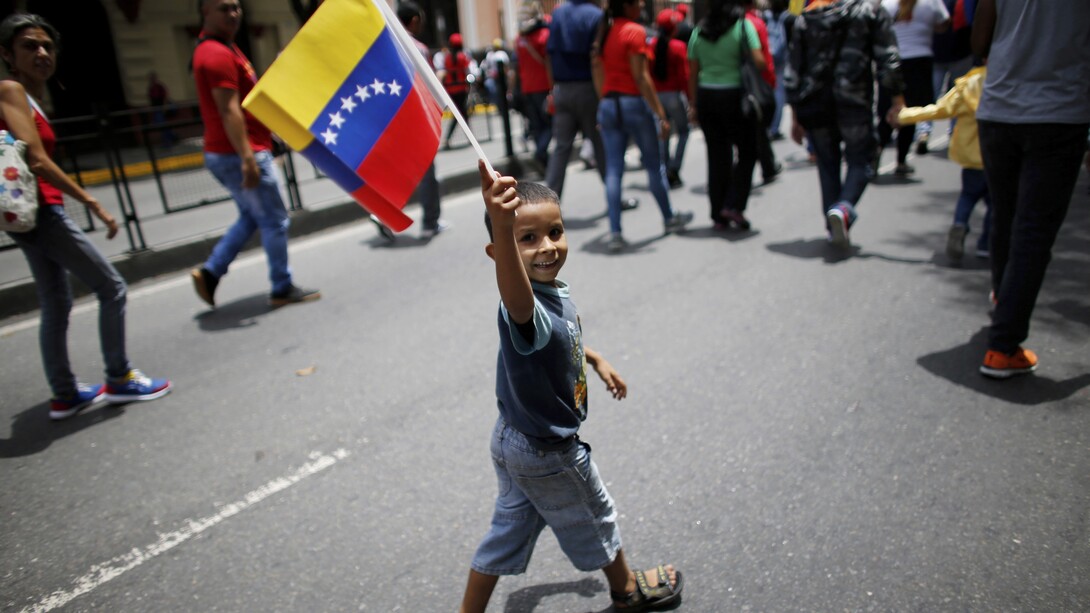 Un niño con la bandera venezolana por las calles de Caracas