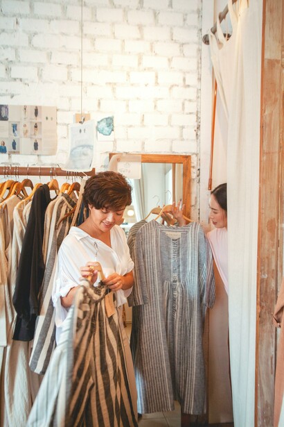 Moça experimenta roupas de segunda mão com a amiga