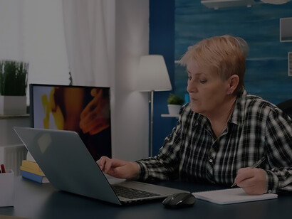 Diligent elderly woman performing tasks on the computer