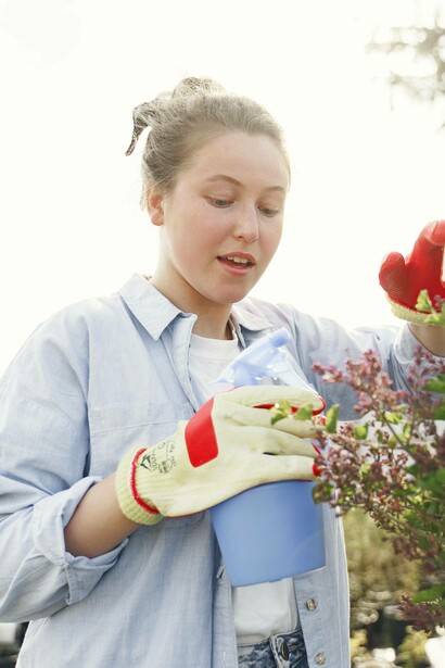 Woman observing the progress of her plant 
