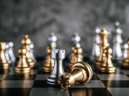 A chessboard displaying strategic moves with gold and silver pieces, highlighting intricate gameplay