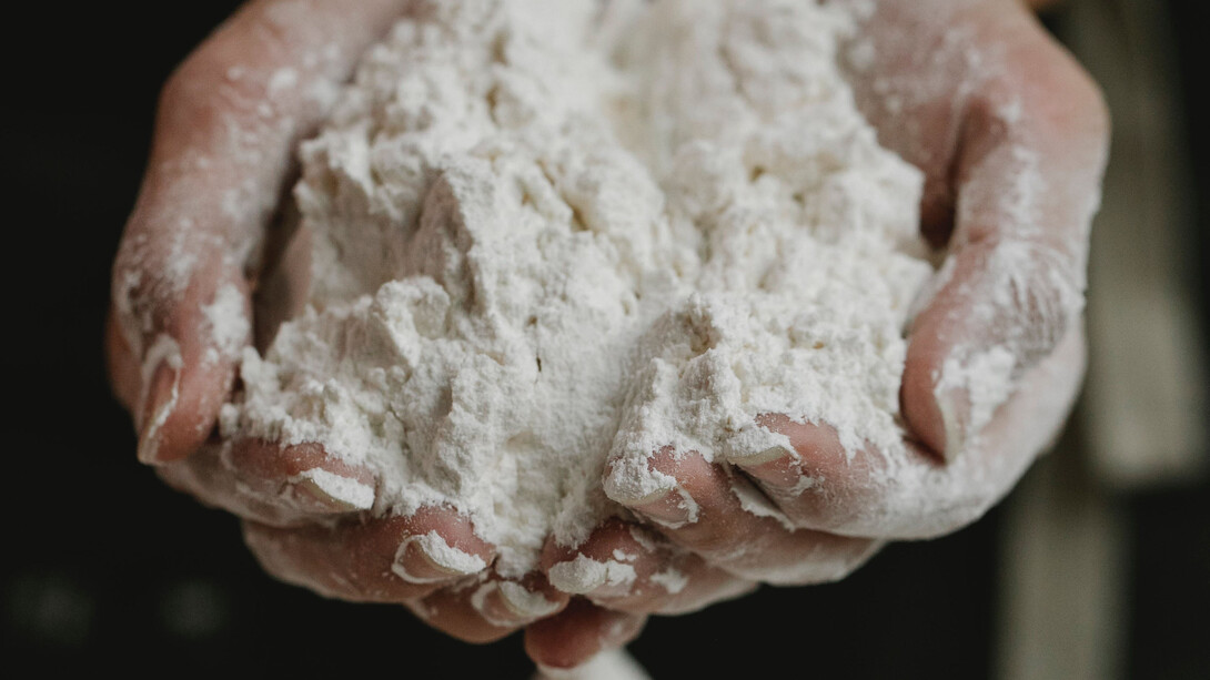 Mãos preparam um alimento à base de farinha de trigo