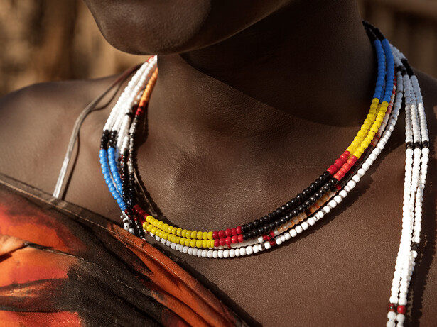 A close-up of beadwork worn by a woman, representing cultural identity and personal history