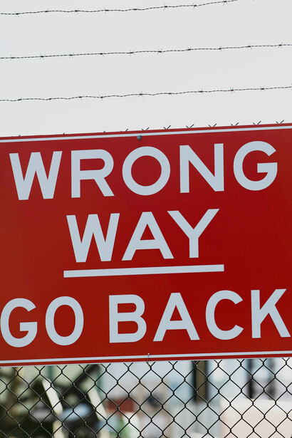 A tree from which a "wrong way" sign hangs, representing the power of the negative