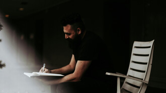 Hombre tomando notas en su cuaderno: todo diálogo es una reflexión y toda reflexión es un diálogo