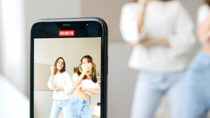 Jovens amigas dançam para vídeo no celular que depois será postado nas redes sociais