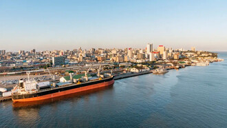 Vista panorâmica do porto de Maputo, com o horizonte urbano e as águas da baía em destaque. A dinâmica econômica moçambicana exige que as empresas adotem métodos quantitativos para controlar custos e tomar decisões mais precisas em ambientes de constante transformação