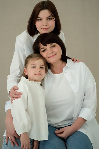 Three generations—grandmother, daughter, and granddaughter—stand together, their resemblance echoing the enduring thread of human nature across time