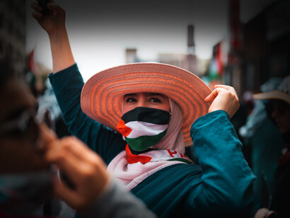 Mujer palestina se cubre el rostro con la bandera de su país en una manifestación contra la guerra en la Franja de Gaza