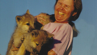 Susan Eirich holding the pups with a wide smile on her face
