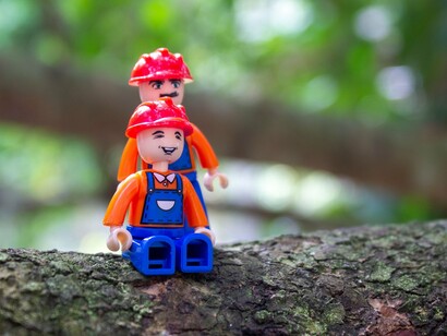 Dois bonecos Playmobil aparecem sobre o tronco de uma árvore em mais uma composição fotográfica criativa. Foi com cenas simples em ambientes reais que Maria Moysés conquistou milhares de admiradores nas redes sociais