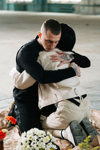 Pareja fríamente abrazada sobre una sábana con flores