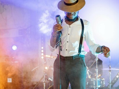 Cantor se apresenta para seu público. Fica-nos claro que é preciso potenciar esta prática. Ela representa uma atitude. E eles bem sabem ser ousados quanto misteriosos