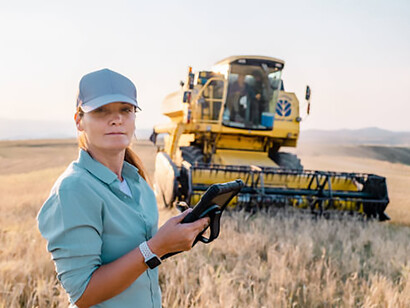 Female farmer uses a digital tablet to monitor crops in a smart farming field