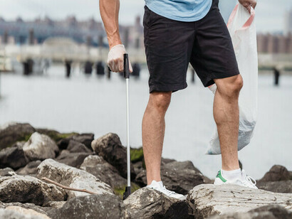 Jovem viajante participa de ação sustentável no Porto da cidade de Santos, São Paulo