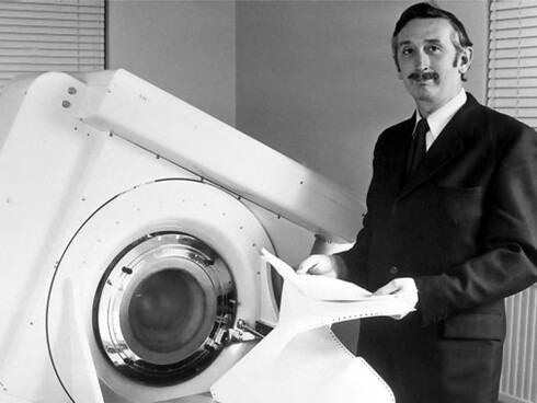 Godfrey Newbold Hounsfield junto a su invento, el EMI Scanner