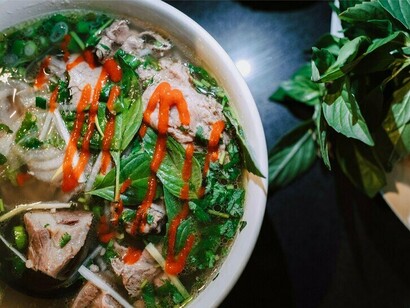 A bowl of pho with chunks of beef and fresh herbs, ready to be enjoyed, highlighting this flavorful and beloved Vietnamese staple