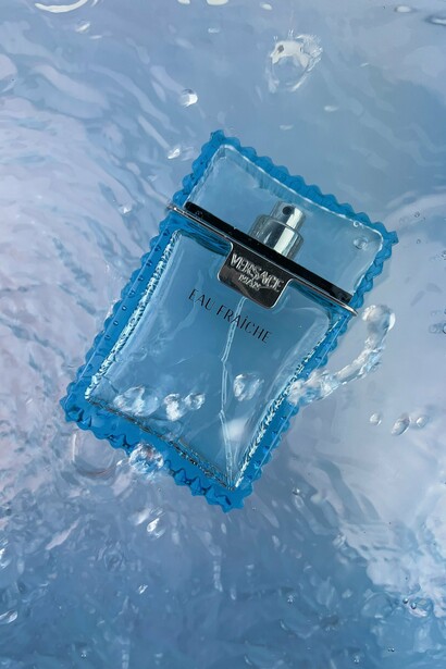 Versace Eau Fraîche surrounded by blue water, symbolizing the brand’s interpretation of freshness, sophistication, and modern luxury