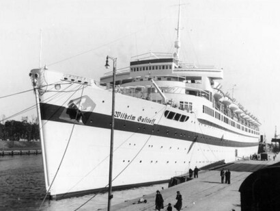 Vista lateral do Wilhelm Gustloff atracado em águas calmas. Anos depois, essas mesmas águas testemunhariam uma evacuação desesperada e um desastre de proporções devastadoras