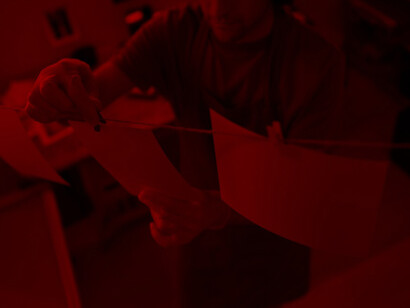 The craft of photography as a man expertly develops photos in a striking red room, embodying the essence of visual storytelling and artistic expression