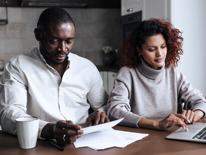 A couple making financial decisions side by side, reflecting the value of teamwork in creating lasting stability