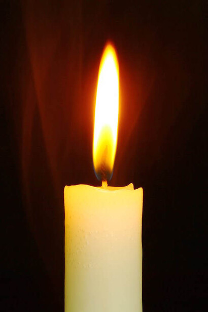 Candela bianca illuminata al buio