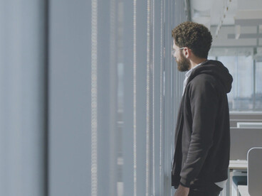 With his eyes fixed on the horizon, the man contemplates the devastating cost of a workplace culture that prioritises profit over people’s well-being