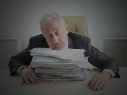A frustrated entrepreneur crumpling documents amid piles of government paperwork