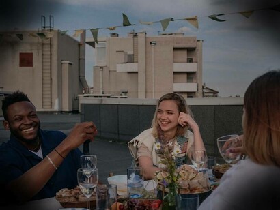 Persone che pranzano insieme sul terrazzo di un palazzo