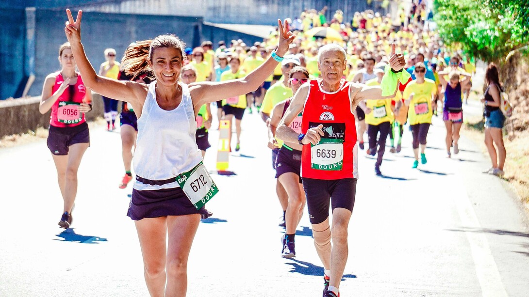 A group of marathon runners approaching the finish line, looking happy and proud to have completed the run