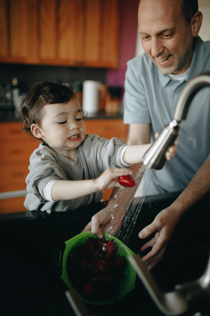 A imagem mostra a conexão entre pai e filho durante a atividade de cozinhar juntos, refletindo a influência positiva das relações interpessoais no aprendizado e na afetividade